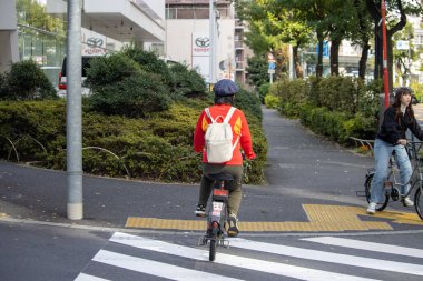 Tokyo, Japonya, 4 Kasım 2023: Görünür Toyota Tabelasıyla Şehir Caddesinde Bisikletçiler