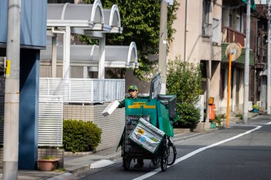 Tokyo, Japonya, 5 Kasım 2023: Büyük bir Kargo Kutusuyla Bisiklete Binen Teslimat Kişi