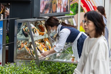 Tokyo, Japonya, 5 Kasım 2023: Açık hava pazarında yemek sergileyen kadın
