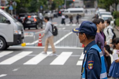 Tokyo, Japonya, 5 Kasım 2023: Shibuya 'daki yaya trafiğini izleyen güvenlik görevlisi