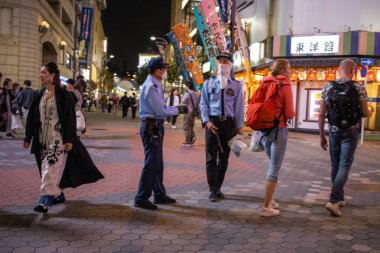 Tokyo, Japonya, 5 Kasım 2023: Nöbetçi Yaya ve Polis Memurlarıyla Gece Sahnesi