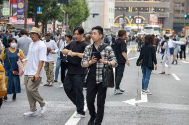 Tokyo, Japonya, 5 Kasım 2023: Kalabalık kalabalık bir caddeyi geçiyor