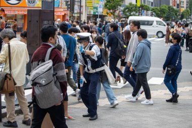 Tokyo, Japan, November 5 2023: Police Officer Directing Pedestrians clipart