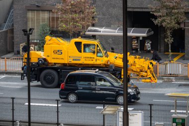 Tokyo, Japonya, 5 Kasım 2023: Şehir caddesinde inşaat makineleri ve işçiler