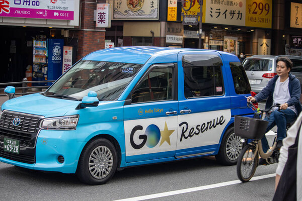 Tokyo, Japan, November 5 2023 : Go Reserve Branded Car and Cyclist on Street