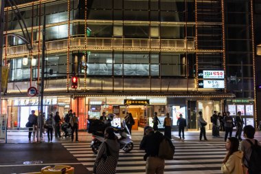 Tokyo, Japonya, 6 Kasım 2023: Aydınlatılmış Bina Cephesi ve Gece Yayaları