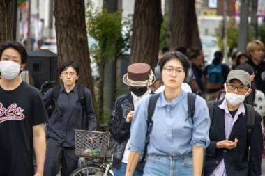 Tokyo, Japonya, 6 Kasım 2023: Yayaların maske taktığı yoğun sokak sahnesi