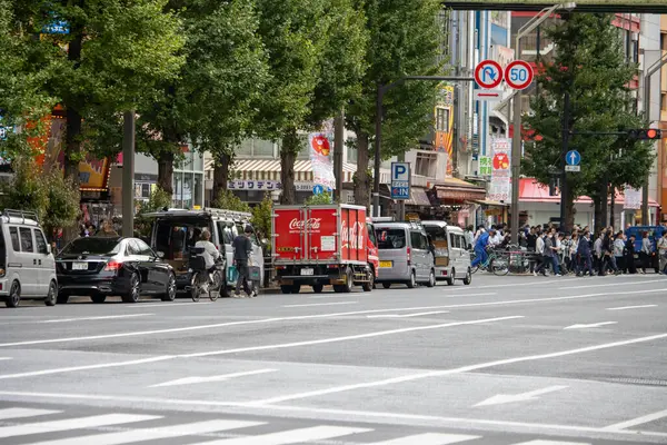 Tokyo, Japonya, 6 Kasım 2023: Coca-Cola dağıtım kamyonu ve yayalarla şehir sokak sahnesi