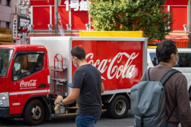 Tokyo, Japonya, 6 Kasım 2023: Yoğun caddede Coca-Cola dağıtım kamyonu