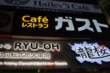 Tokyo, Japan, November 6, 2023: Illuminated Signboards of a Cafe and Mutton Skewer Restaurant at Night clipart