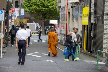 Tokyo, Japan, 6 November 2024: Urban Scene with Diverse Pedestrians and Street Signs clipart