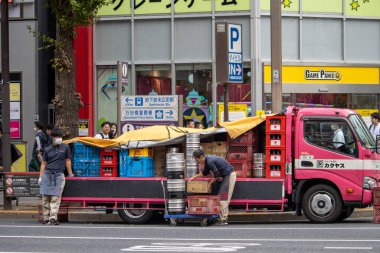 Tokyo, Japonya, 6 Kasım 2024: İşçi Malzemeleri Yoğun Cadde 'deki bir kamyona yükleyen işçiler