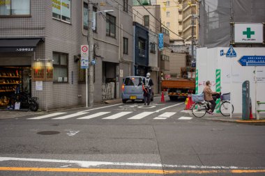 Tokyo, Japan, 6 November 2024: Urban Street Scene with Pedestrians and Shops clipart
