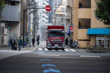 Tokyo, Japan, 6 November 2024: Urban Street Scene with Red Truck and Pedestrians clipart