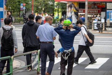 Tokyo, Japonya, 6 Kasım 2024: İnşaat işçisi ve yayalarla Şehir Sahnesi