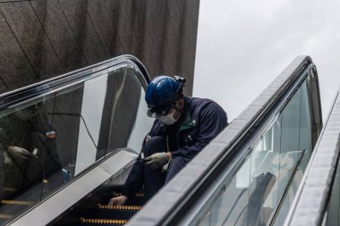 Tokyo, Japonya, 7 Kasım 2024: Yürüyen Merdivenleri Denetleyen Bakım İşçisi
