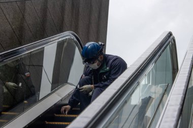 Tokyo, Japonya, 7 Kasım 2024: Yürüyen Merdivenleri Denetleyen Bakım İşçisi