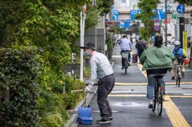 Tokyo, Japonya, 7 Kasım 2024: Bisikletçiler ve İşçilerle Şehir Caddesi