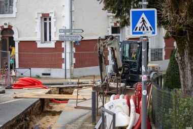 Fransa, 10 Mart 2024: Kazıcı ve yaya geçidi işaretli inşaat sahası
