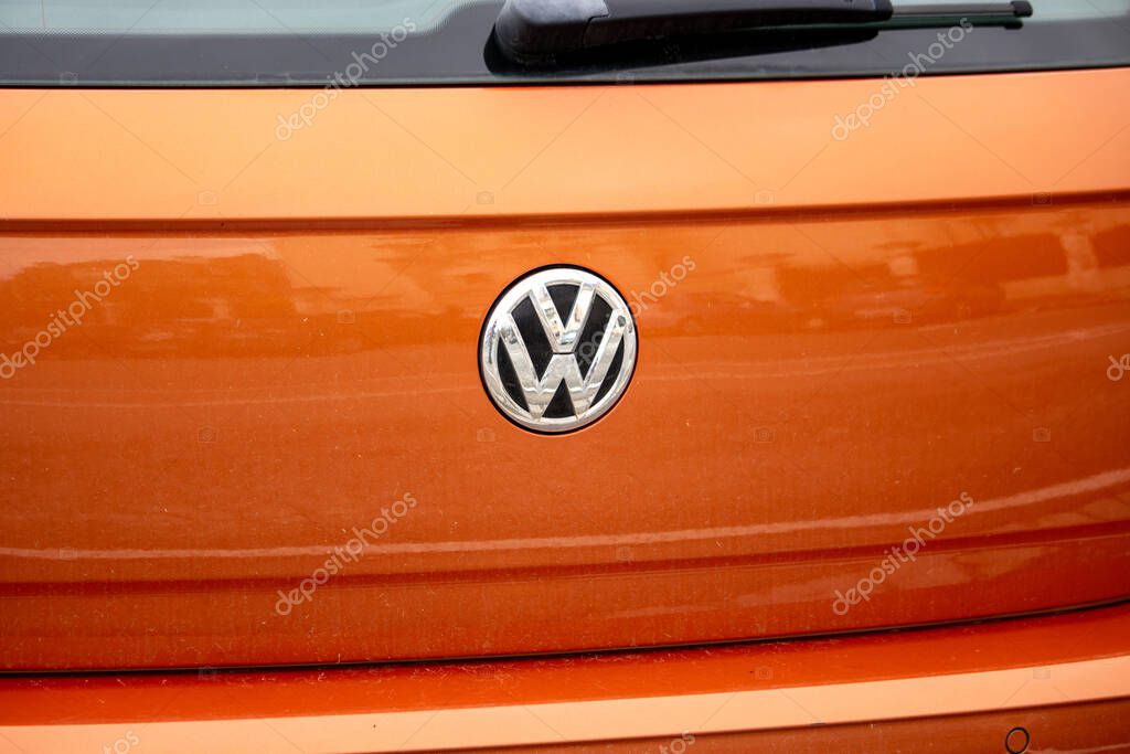 France, 10 March 2024: Close-up of Volkswagen logo on orange vehicle