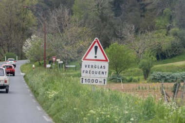 Fransa, 07 Nisan 2024: Kırsal bir yoldaki sık buzlar için uyarı işareti