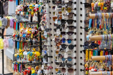 Fransa, 07 Nisan 2024: Renkli anahtarlıklar ve güneş gözlüklerini gösteren hediyelik eşya standı