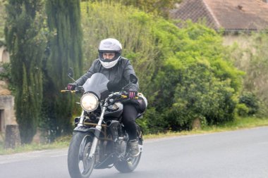 France, 07 April 2024: Motorcyclist Riding Through Countryside clipart