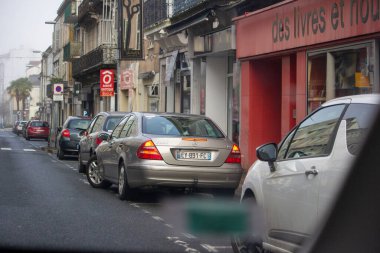 France, 30 March 2024: Urban Street Scene with Parked Cars and Bookstore clipart