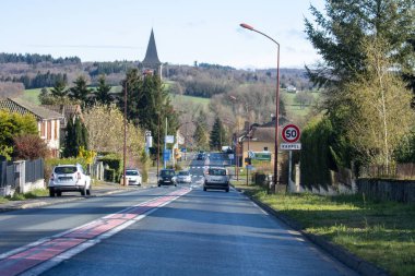 Fransa, 30 Mart 2024: Konut evleri ve karayolu trafiğiyle küçük bir kasaba manzarası
