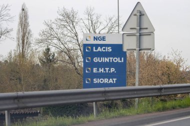 Fransa, 21 Mart 2024: Kırsal Fransa 'da yol kenarındaki şirket tabelasında birden fazla işletme adı yer alıyor