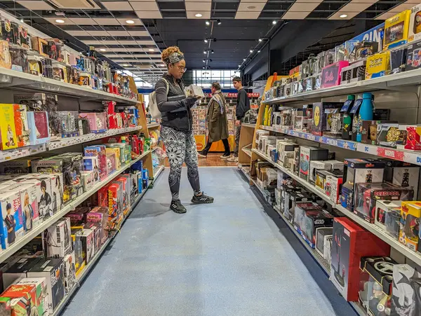 stock image France, 16 March 2024: A young adult browsing in a toy and hobby shop aisle