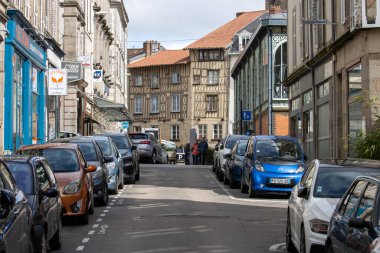 Fransa, 30 Mart 2024: Park halindeki arabalarla dolu sevimli eski bir kasaba caddesi.