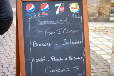 France, 10 March 2024: Restaurant chalkboard advertising burgers and salads. clipart