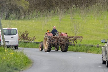 Fransa, 07 Nisan 2024: Traktördeki çiftçi kırsal yolda