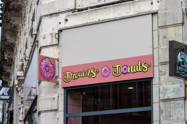 France, 30 March 2024: Dreams and Donuts store in an urban setting. clipart