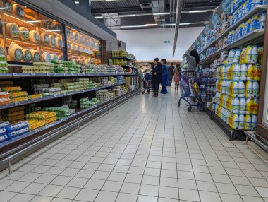 Fransa, 16 Mart 2024: İnsanlar süpermarket koridorlarında alışveriş yapıyorlar, etrafları çeşitli market eşyalarıyla çevrili..