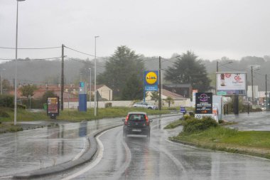 Fransa, 01 Nisan 2024: Lidl imzalı yağmurlu banliyö caddesi