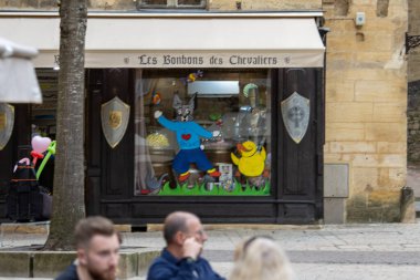 Fransa, 07 Nisan 2024: Les Bonbons des Chevaliers adlı bir şekerci dükkanının vitrini, büyüleyici bir şehir ortamında çizgi film karakterleriyle süslenmiş..
