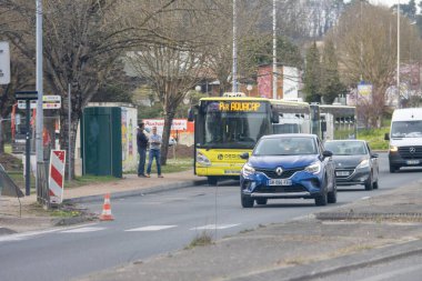 Fransa, 21 Mart 2024: Şehir merkezinde sarı otobüs ve arabalarla dolu cadde sahnesi