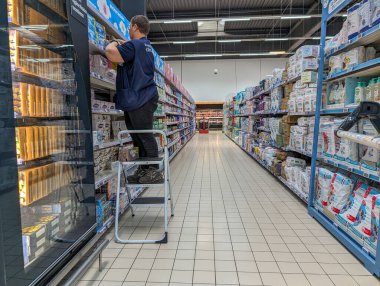 Fransa, 26 Nisan 2024: Süpermarket koridorunda çalışan stoklama ürünleri