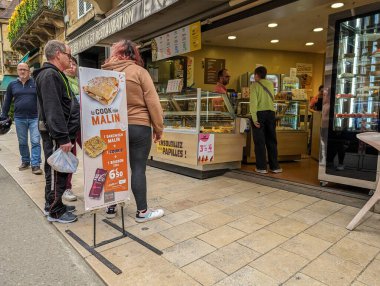 Fransa, 7 Nisan 2024: Şehir manzarası bir fırın önünde günlük yaşamı yakalıyor