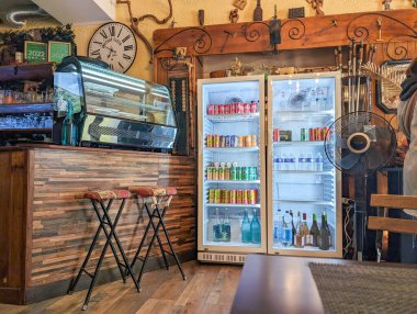 Fransa, 18 Nisan 2024: Buzlu içecek vitrinli bir köy kahvesi ve bar tabureli bir tezgah.