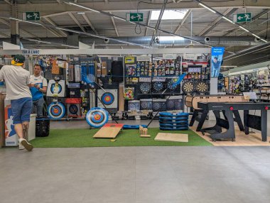 France, 9 May, 2024: Display of various sports and leisure equipment in a retail store, including targets and dartboards. clipart
