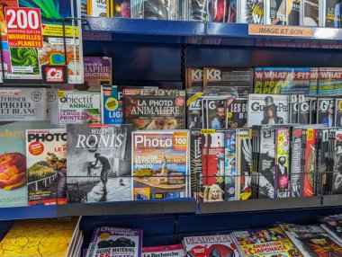 France, 08 May 2024: Magazine rack displaying various publications in a store clipart