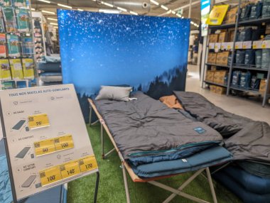 France, 09 May 2024: Display of camping gear and sleeping bags in an outdoor equipment store clipart