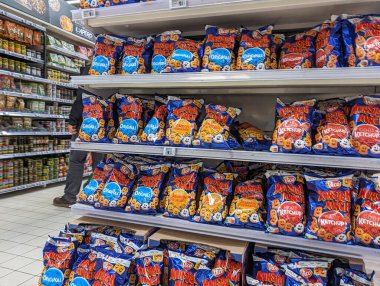 France, 08 May 2024: Supermarket shelves stocked with snack products clipart