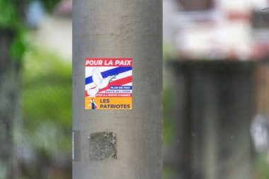 Fransa, 19 Mayıs 2024: Barış ve vatanseverlik değerlerini destekleyen bir elektrik direğindeki siyasi poster.