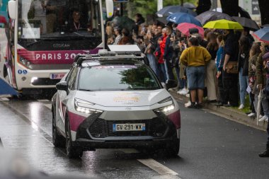 Fransa, 22 Mayıs 2024: Paris 2024 Olimpiyat aracı yağmurda kalabalık maratonu yönetiyor