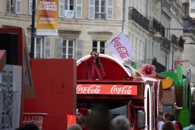 Fransa, 22 Mayıs 2024: Coca-Cola tanıtım etkinliği geçit töreni arabası ve Perigueux 'da Coca-Cola bayrağı taşıyan bir kişi.