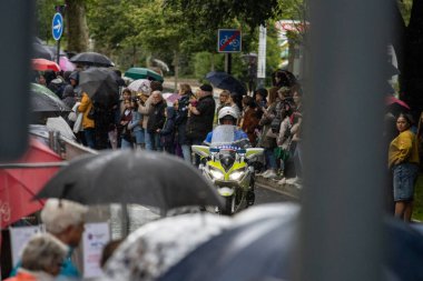 France, 22, May, 2024: Police motorcade during public event with crowd and umbrellas clipart